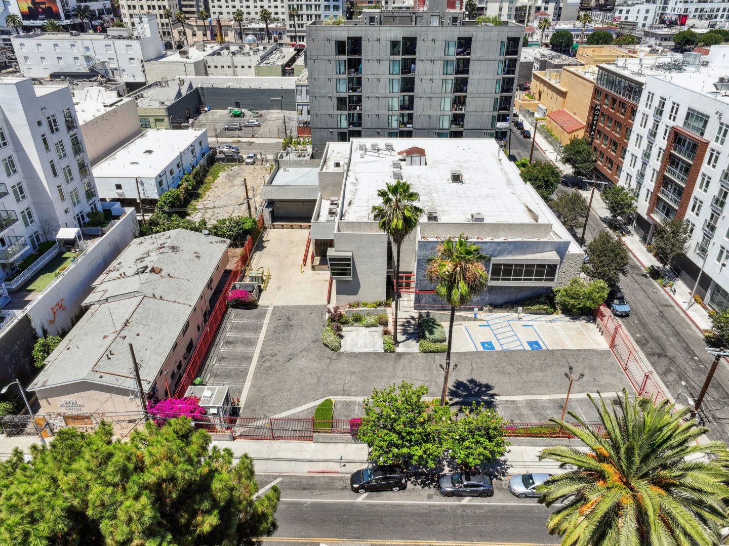 Aerial view of the freestanding Selma House compound showing its gated, secured on-site surface parking lot and the surrounding Hollywood blocks
