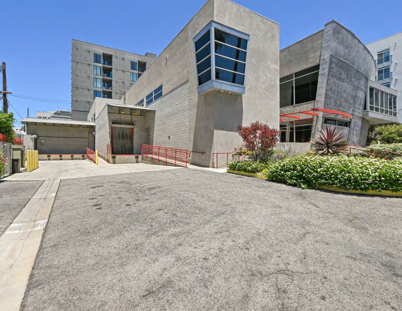 Selma House in its Hollywood neighborhood context, a concrete campus with landscaping and a residential tower behind